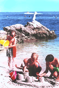 Barn som leker p stranden